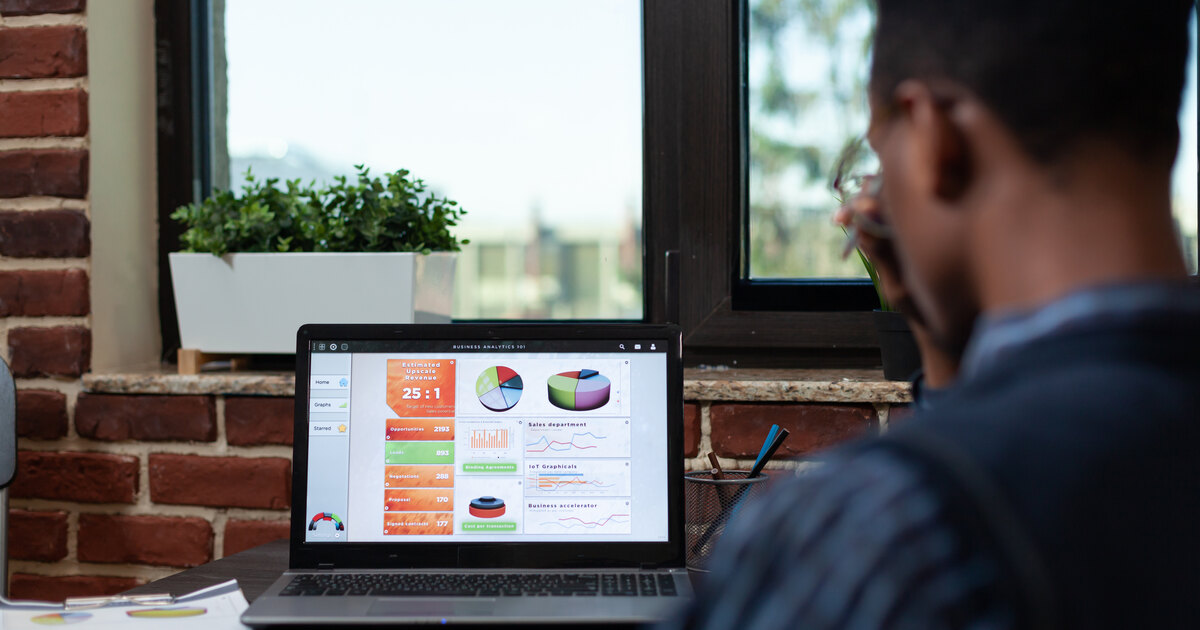 Marketer reviewing a marketing analytics dashboard of charts and conversion metrics on a laptop screen